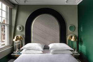 a bedroom with a bed and a large mirror at The Henrietta Hotel in London