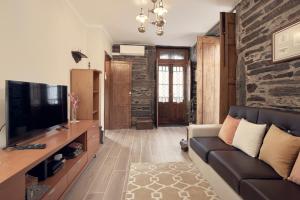 a living room with a couch and a tv at Casa do Largo da Igreja in Vila Nova de Foz Coa