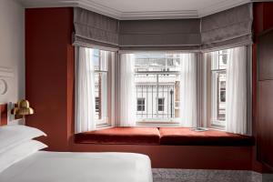 a bed sitting next to a window in a room at The Henrietta Hotel in London