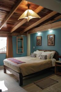 ein Schlafzimmer mit einem großen Bett und einer Holzdecke in der Unterkunft Doña Catta Casa Boutique in Ollantaytambo