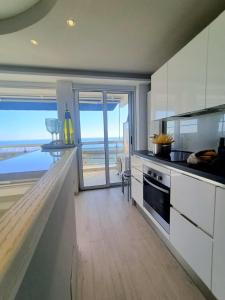 a kitchen with white cabinets and a view of the ocean at Belleview in Roquebrune-Cap-Martin