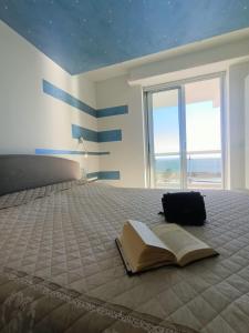 an open book laying on a bed with a window at Belleview in Roquebrune-Cap-Martin