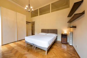 a bedroom with a white bed and a wooden floor at Duomo Luxury House in Florence
