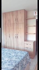 - une chambre avec des placards en bois et un lit dans l'établissement Flat no Hotel Fazenda Monte Castelo em Gravatá - PE, à Gravatá