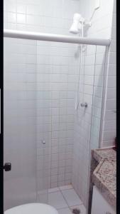 La salle de bains est pourvue d'une douche en verre et de toilettes. dans l'établissement Flat no Hotel Fazenda Monte Castelo em Gravatá - PE, à Gravatá