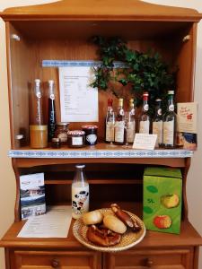 a shelf with bottles of alcohol and a plate of food at MoarHof Feilnbach in Bad Feilnbach