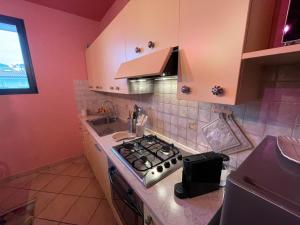 a kitchen with a stove top oven next to a sink at The Loft E&E Cinecittà in Empoli