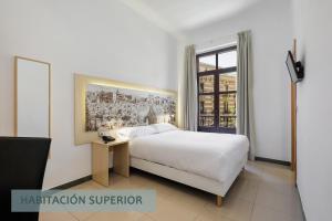 a bedroom with a white bed and a window at Atenas Granada in Granada