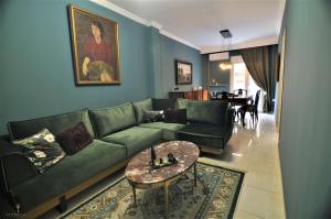 a living room with a green couch and a table at Zennova #4 Vintage City Center Apt in Thessaloniki