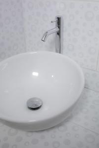 a white sink in a bathroom with a faucet at Casa privada con vista a las montañas Dona Catta in Ollantaytambo +36 photos