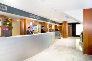 two men sitting at a counter in a lobby at Catalonia Barcelona 505 in Barcelona