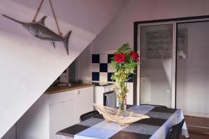 una cocina con una mesa con un jarrón con una flor en Da Mata Kite&Surf House, en Lajares