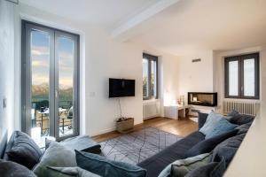 a living room with a couch and a tv at Ortensie & Oleandri al Lago - by MyHomeInComo in Argegno