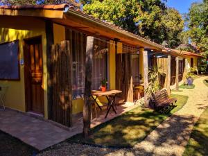 a small yellow house with a table in the yard at Toca do Roka in Socorro