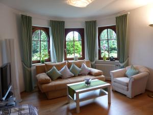 a living room with a couch and two windows at Schwarzwaldturmzimmer Lahr in Lahr