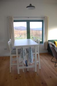 una mesa y sillas blancas en una habitación con ventana en Glas Beag en Spean Bridge