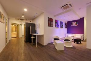 Pokój z białymi krzesłami i fioletową ścianą w obiekcie Hostal Mayerling Centro w Barcelonie