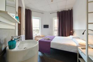 Habitación de hotel con bañera y cama en Hostal Mayerling Centro, en Barcelona