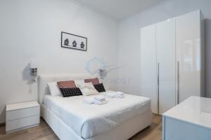 a white bedroom with a white bed and a bathroom at NEW! Completely renovated apt in Vatican! in Rome
