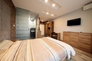 ビャウィストクにあるAPARTVIP Grochowaのベッドと薄型テレビのある寝室