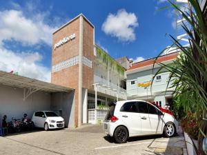 dos autos blancos estacionados frente a un edificio en Super OYO 90730 Padekosan en Tulungagung