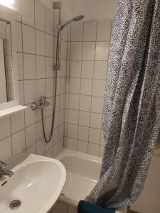 a bathroom with a shower and a sink and a shower curtain at Ankerplatz in Wendtorf