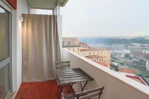 a balcony with a bench and a view of a city at HM – Vilar Apartment in Porto