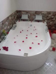 bañera con rosas en el suelo en una habitación en Hotel SARALI, en Doradal