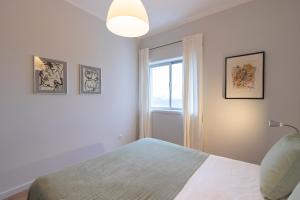 a white bedroom with a bed and a window at HM – Vilar Apartment in Porto