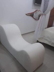 una silla blanca sentada junto a una cama en Hotel SARALI, en Doradal