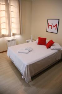 Hotel Murialdo في كاكسياس دو سول: غرفة نوم بسرير كبير ومخدات حمراء