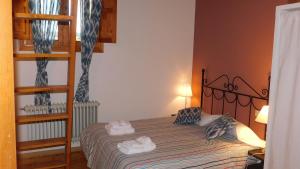 a bedroom with a bed with two towels on it at La Silla de la Reina in Navarredonda de Gredos