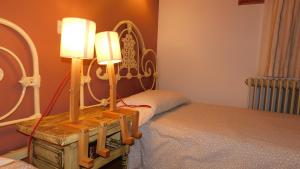 een slaapkamer met een bed en twee lampen op een tafel bij La Silla de la Reina in Navarredonda de Gredos