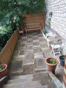 a patio with a bench and tables and plants at Appartement de charme avec parking et terrasse in Besançon