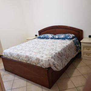 Schlafzimmer mit einem Bett mit einem Kopfteil aus Holz in der Unterkunft Via Sacco in Aosta