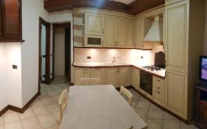 a kitchen with a table and a table and a tv at Via Sacco in Aosta