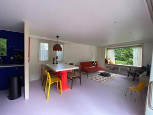 een keuken en een woonkamer met een tafel en stoelen bij Kleurrijk huisje voor 5-personen op de Veluwe in Harderwijk