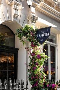 a sign on the side of a building with flowers at The Henrietta Hotel in London