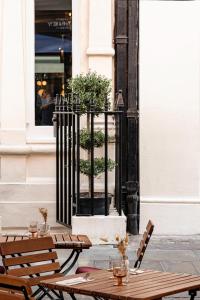 uma mesa de madeira e cadeiras em frente a um edifício em Henrietta Experimental em Londres