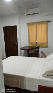 a bedroom with a bed and a table and a window at Cecil Aparta Estudios in Barranquilla