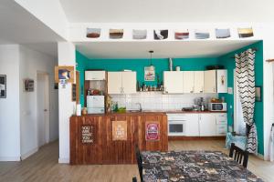 Da Mata Kite&Surf House في لاجاريس: مطبخ مع دواليب بيضاء وطاولة في الغرفة