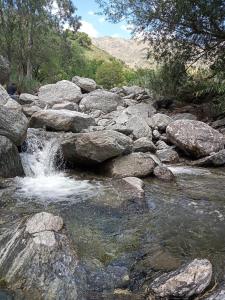 een stroom water met rotsen in een rivier bij al pie del morro in Merlo