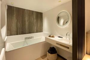 a bathroom with a sink and a tub and a mirror at Le19 Gîte Urbain in Namur +20 photos