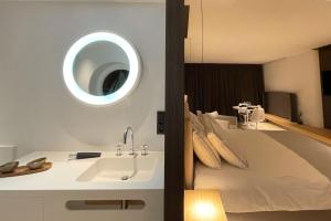 a bathroom with a bed with a sink and a mirror at Le19 Suite Georges & Lucy in Namur