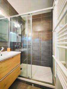 a bathroom with a glass shower and a sink at Agréable T2 neuf -le DÔME- in Riom