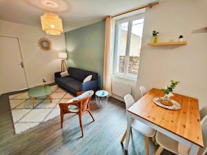 a living room with a table and a couch at Agréable T2 neuf -le DÔME- in Riom