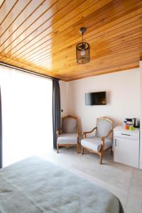a bedroom with a wooden ceiling and two chairs at Villa Nora Butik Otel ve Bungalov in Bursa