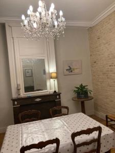 une salle à manger avec une table et un lustre dans l'établissement La Maison d'Hautefeuille, à Boulogne-sur-Mer