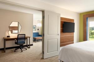 a hotel room with a bed and a desk and a chair at Holiday Inn Express & Suites Searcy, an IHG Hotel in Searcy