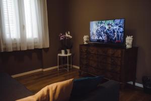 a living room with a flat screen tv on a dresser at Villa Calipso in Mondello